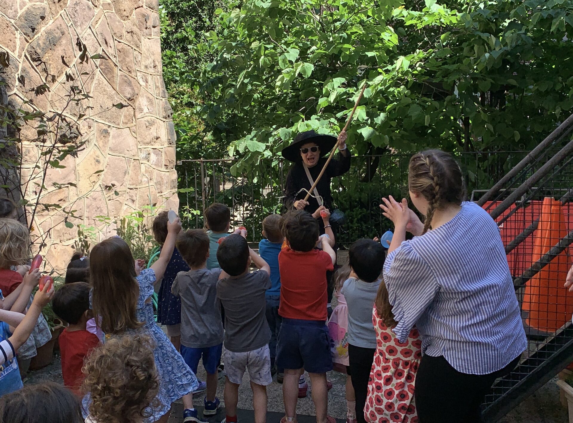 A group of children standing around a tree.