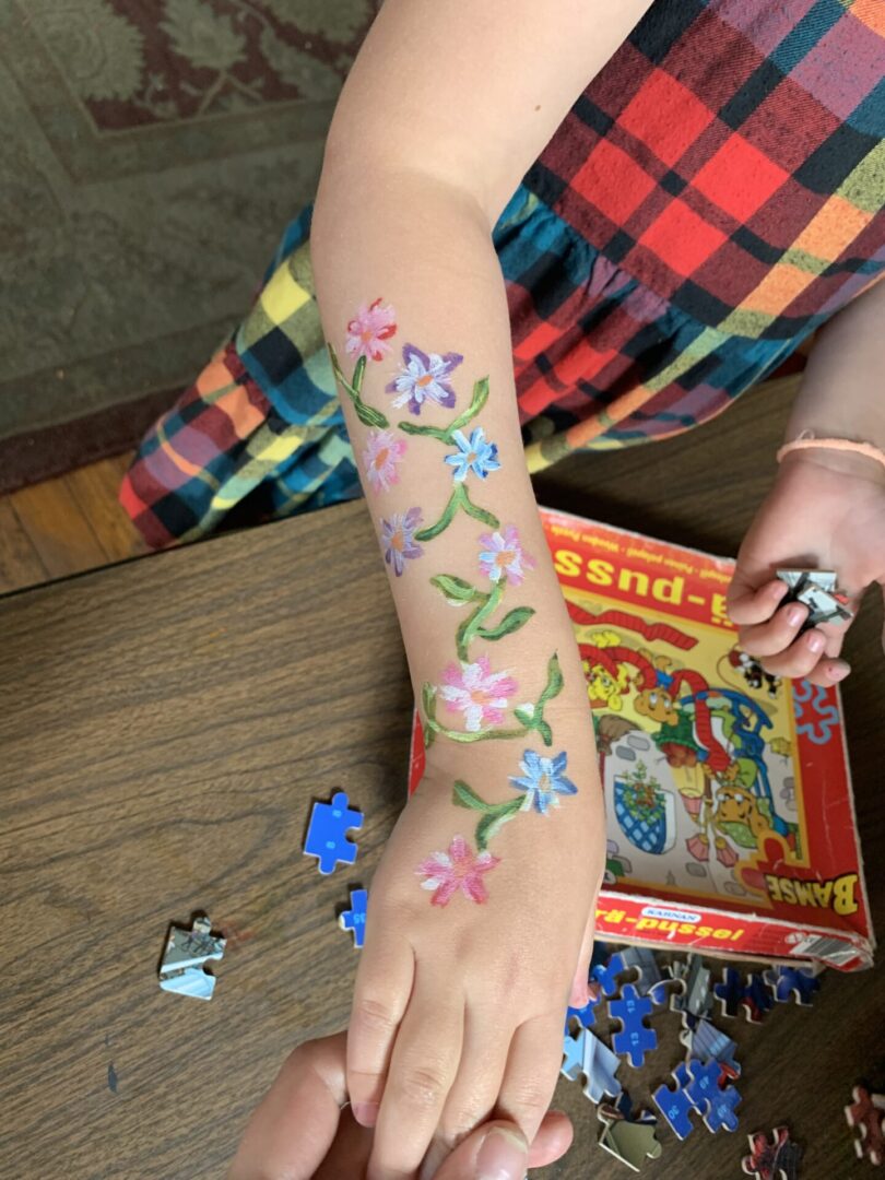 A child with a puzzle on her arm.