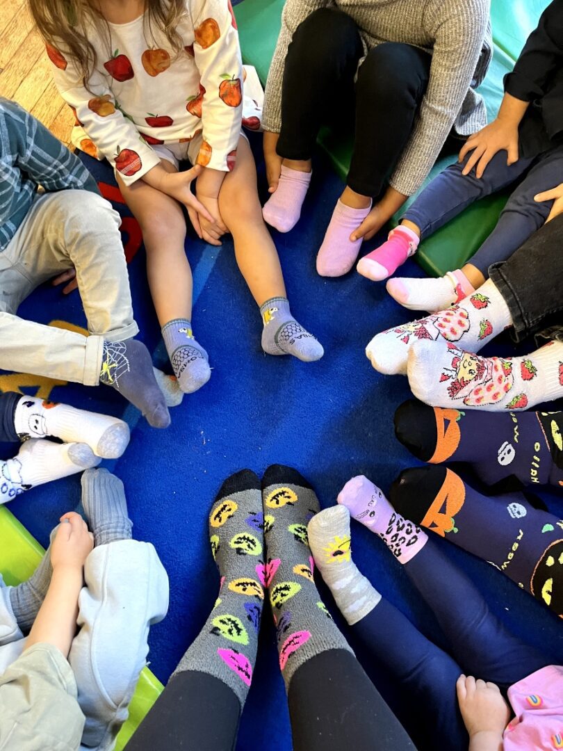 A group of people wearing socks and sitting in the middle of a circle.